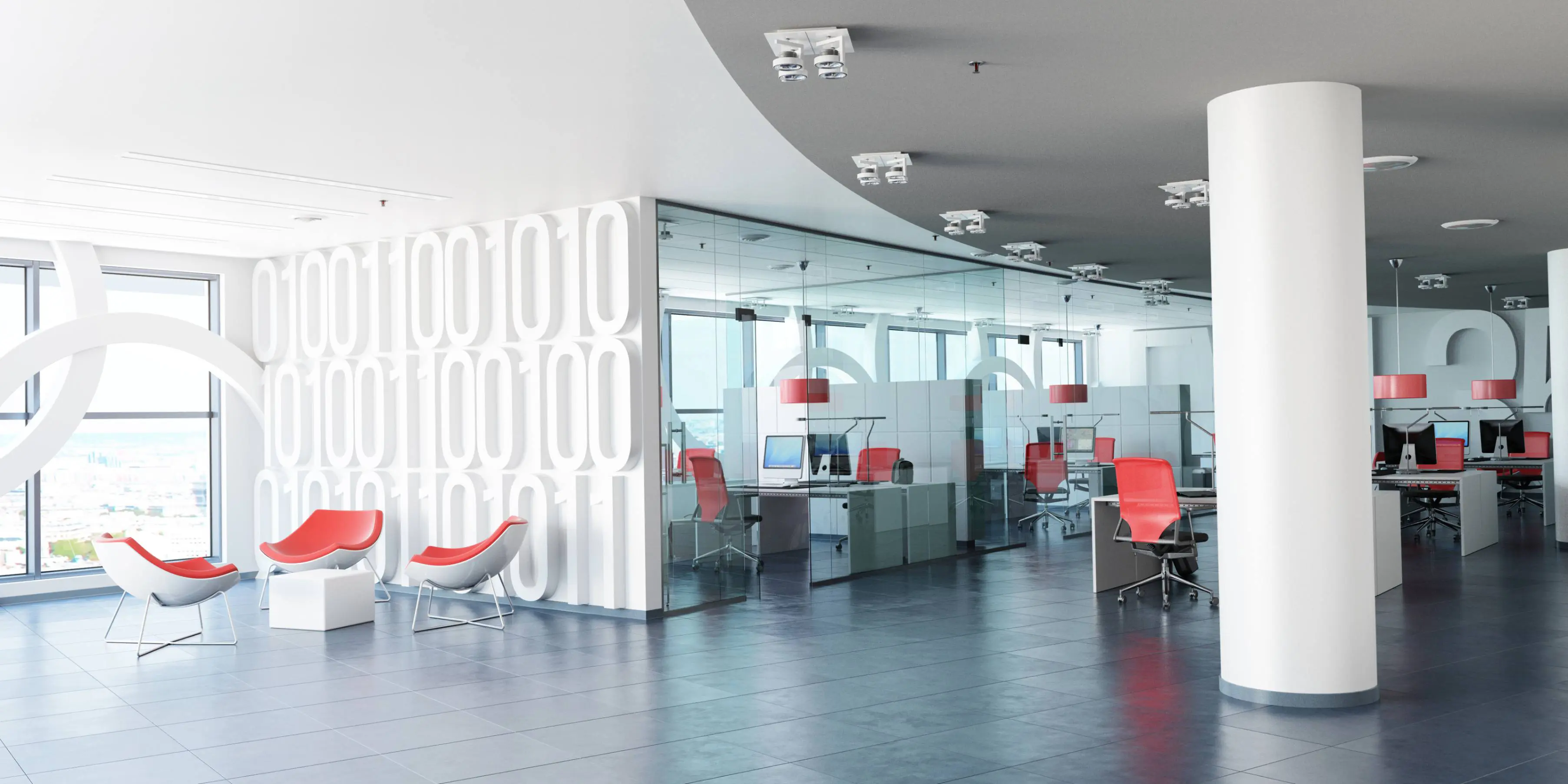 Modern office space with white walls, glass partitions, and red chairs. Open layout includes desks, computers, and ceiling lights. Large windows offer natural light.